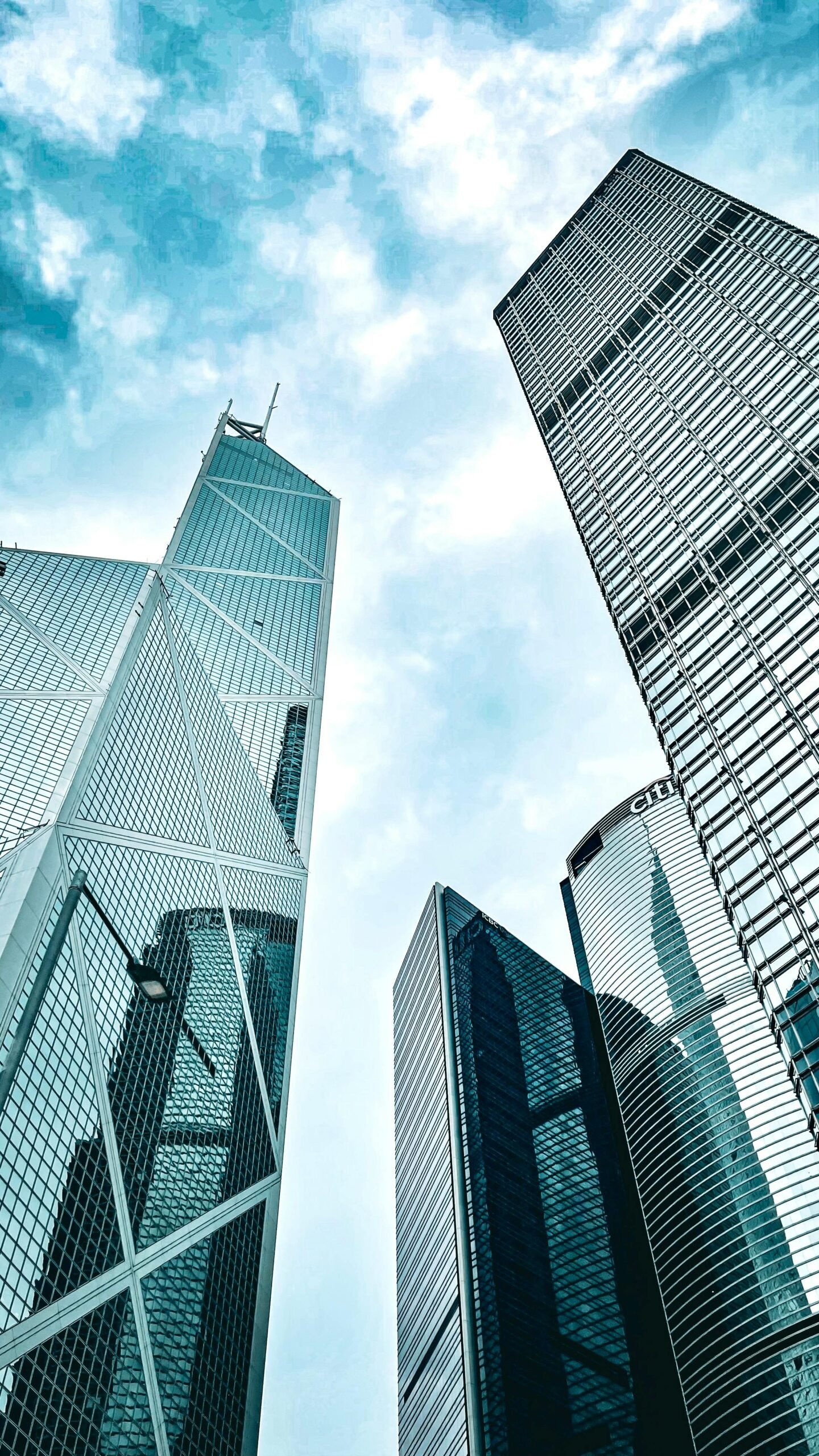 Uplifting view of modern skyscrapers on Hong Kong Island against a blue sky.