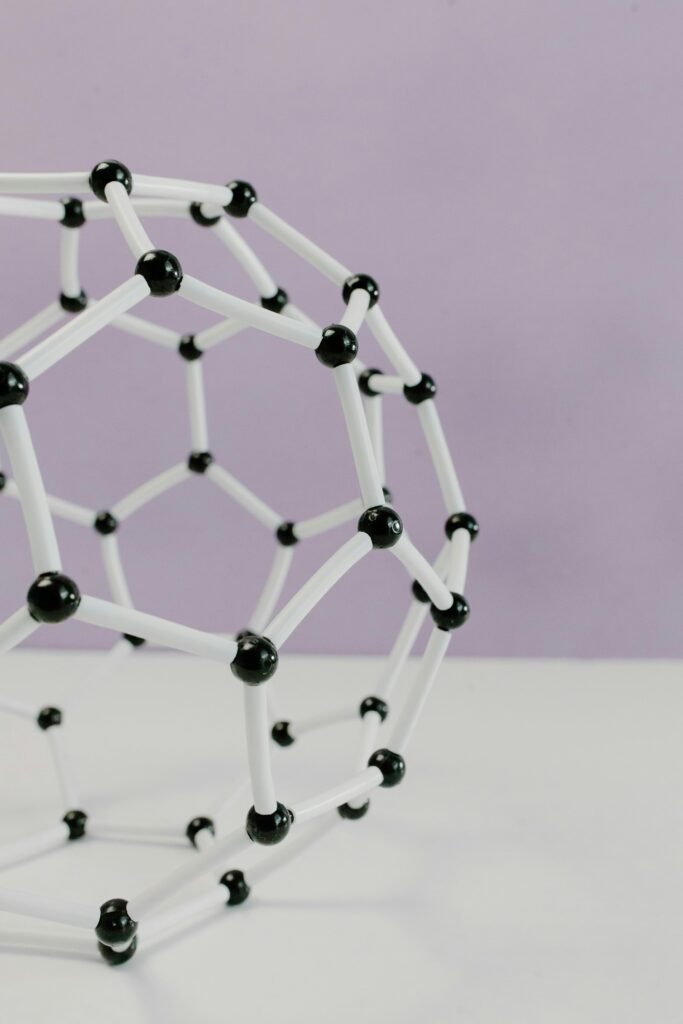 Close-up of a geometric molecular structure model against a pastel background.